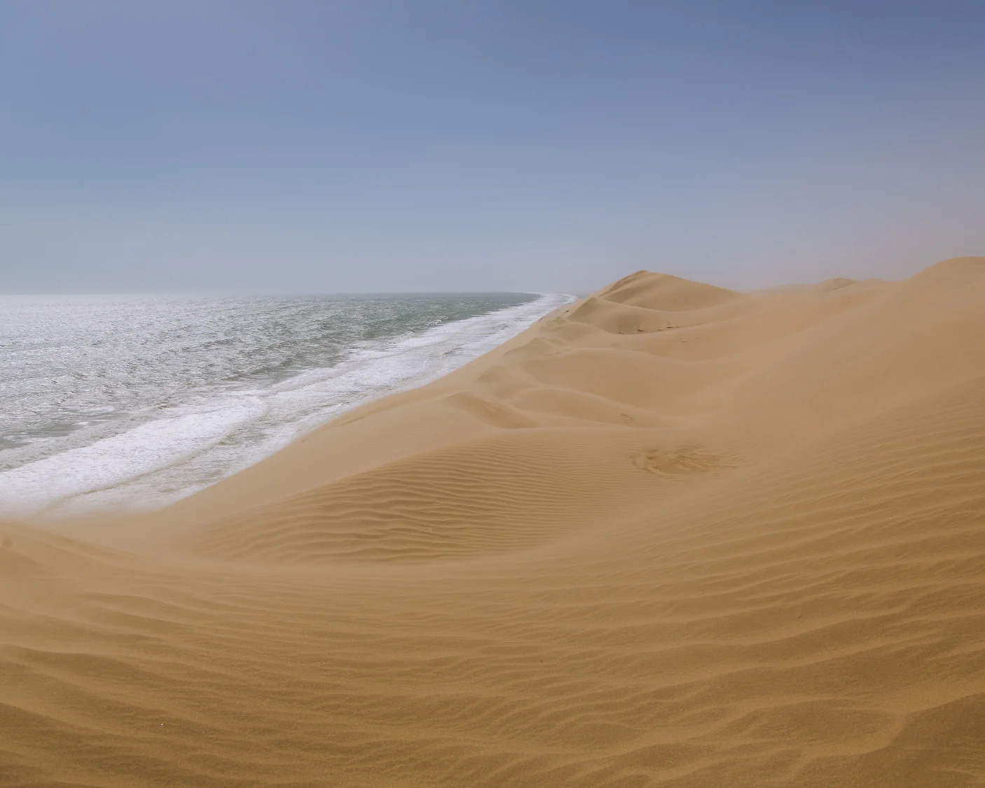 sand dunes meet the ocean at sandwich harbour