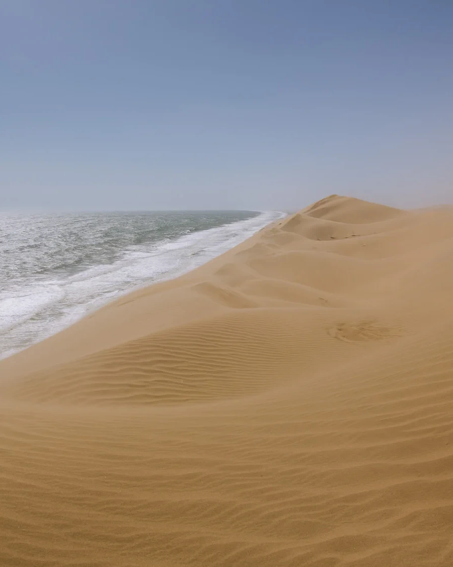 sand dunes meet the ocean at sandwich harbour