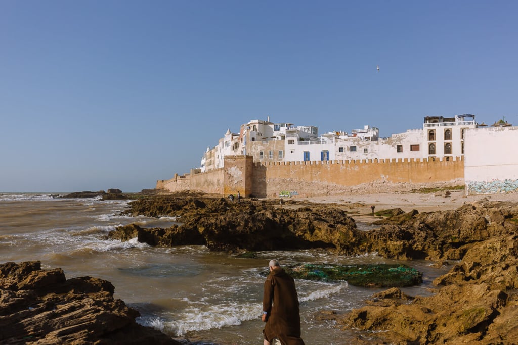 man stands in front of the sea walls in Essaouira Moroco