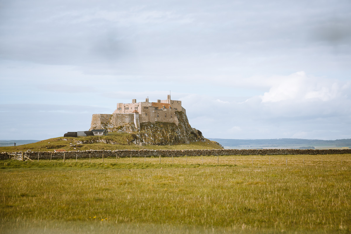 renovated castle on a rock in a grassy field