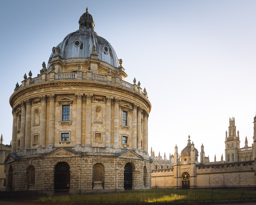 Oval ornate stone building with dappled sunlight