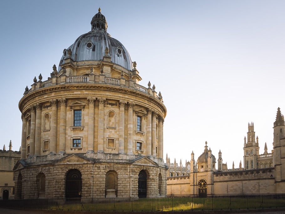 Oval ornate stone building with dappled sunlight