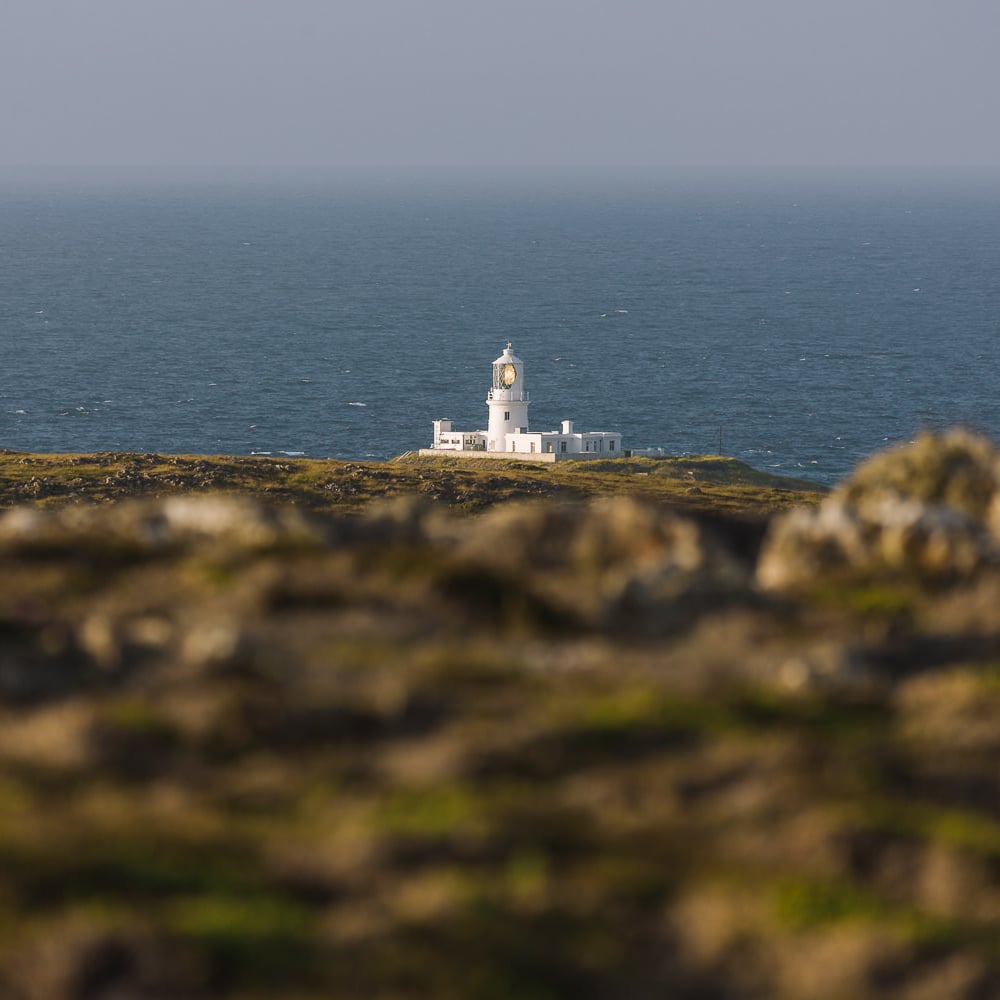white lighthouse in front of the sea