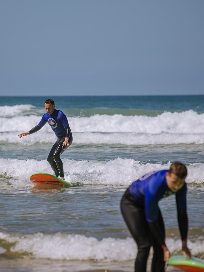 two people surfing in low waves