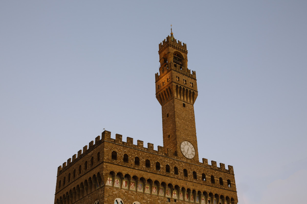 The stone tower of the Palazzo Vecchio and clock face.