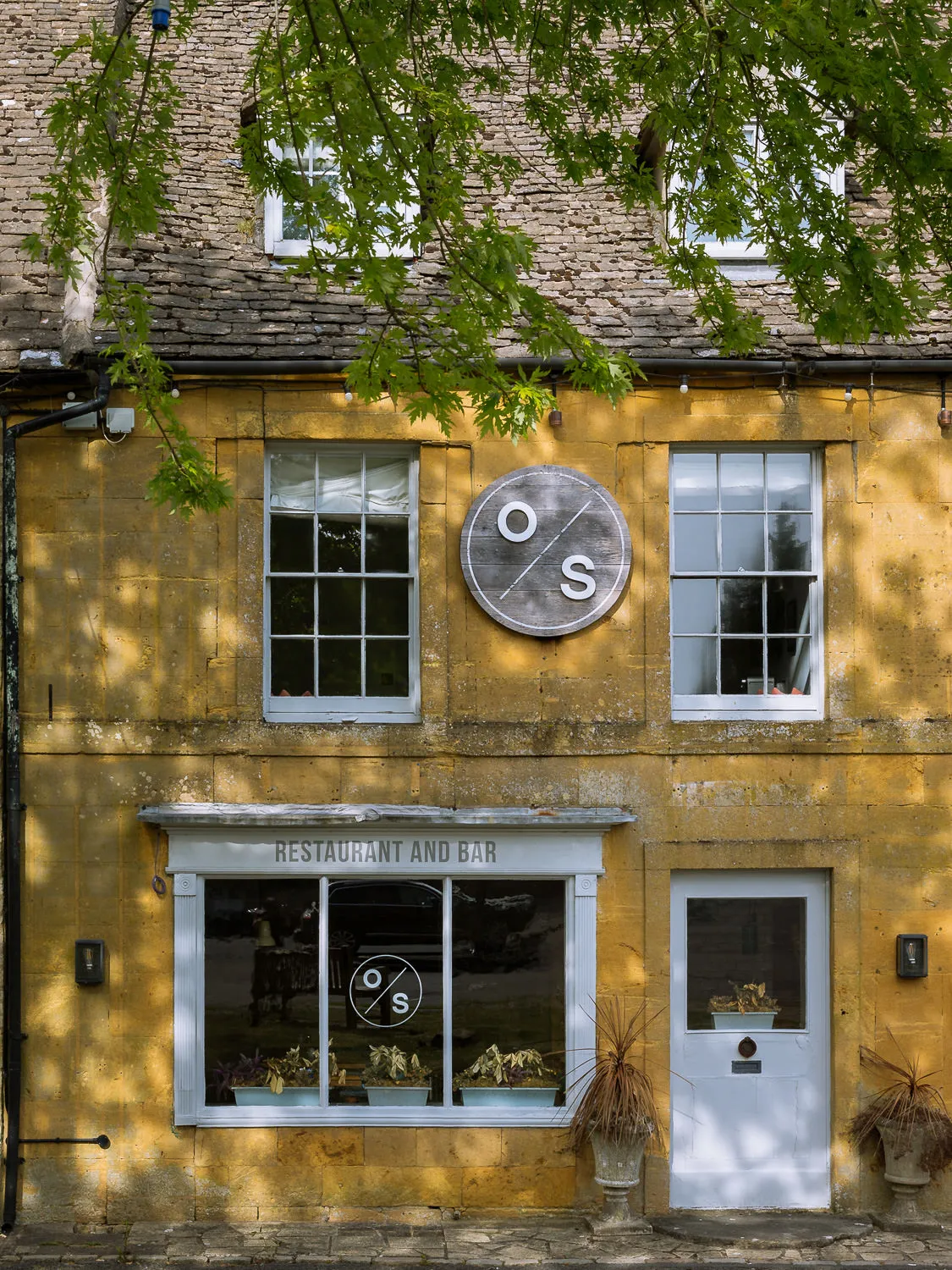 Honey-coloured stone façade of The Old Stocks Inn restaurant and bar in Stow-on-the-Wold.