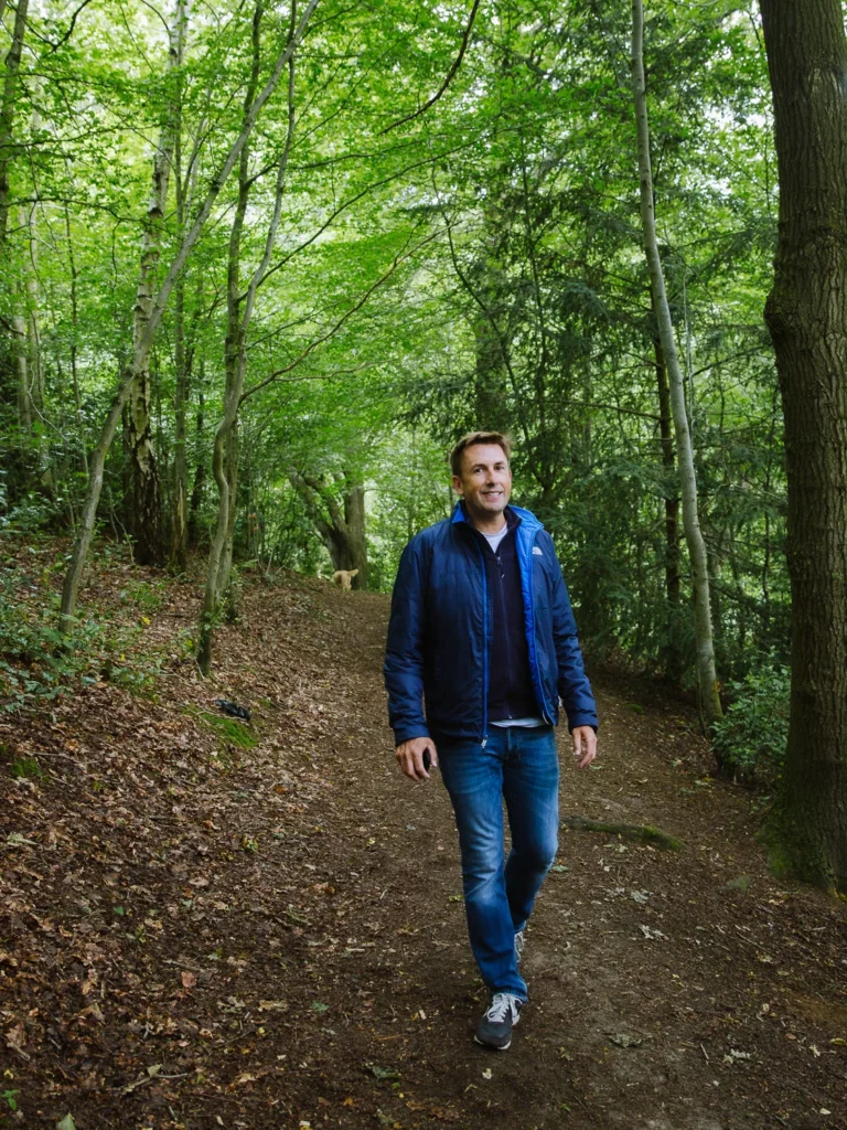 Man walking along a leafy woodland trail near Ludlow, Shropshire