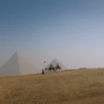 rides on camels in front of the pyramids of giza, egypt
