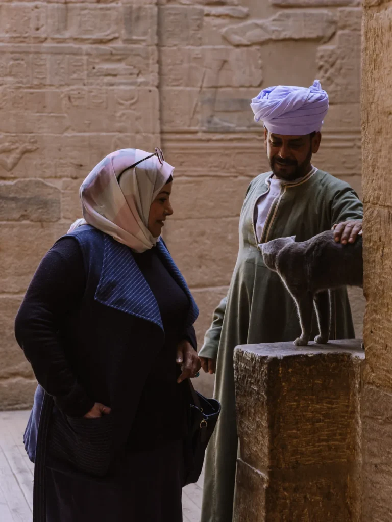 two people playing with a cat in Philae temple aswan