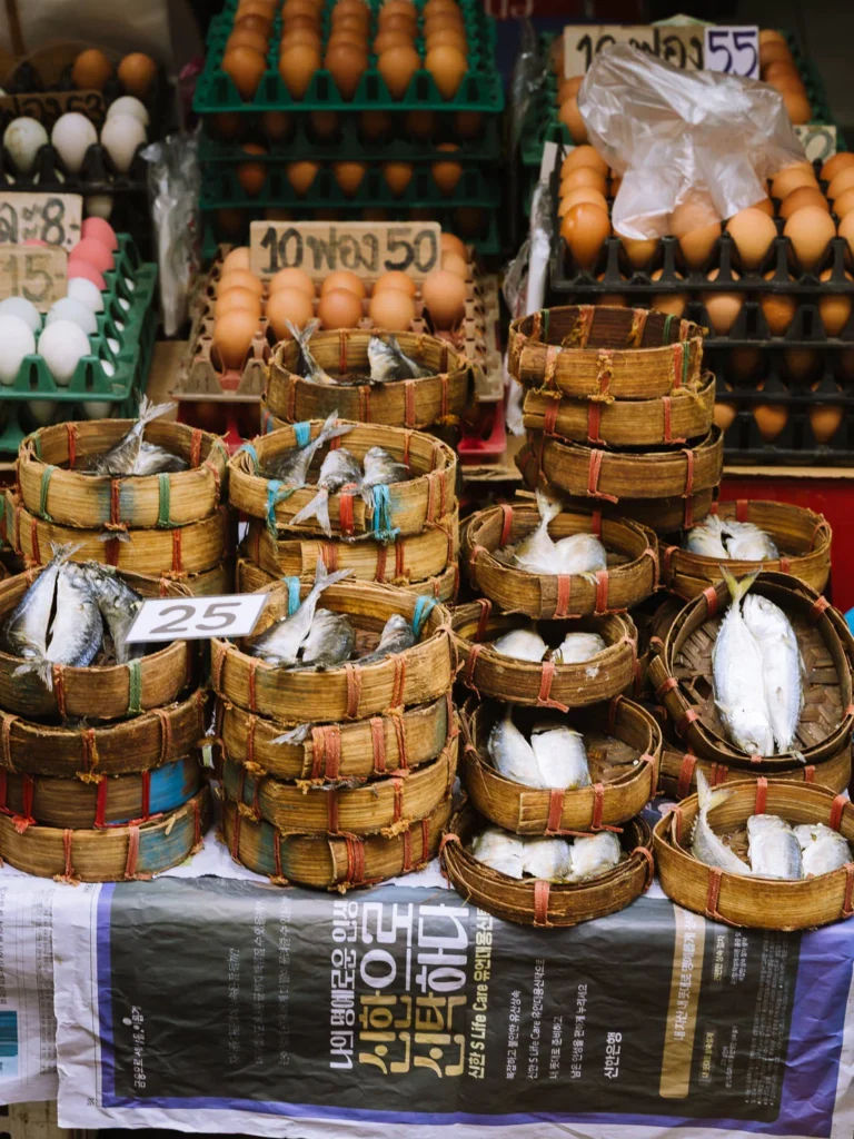 Fresh fish in woven baskets and eggs for sale at Trok Mor morning market, Bangkok
