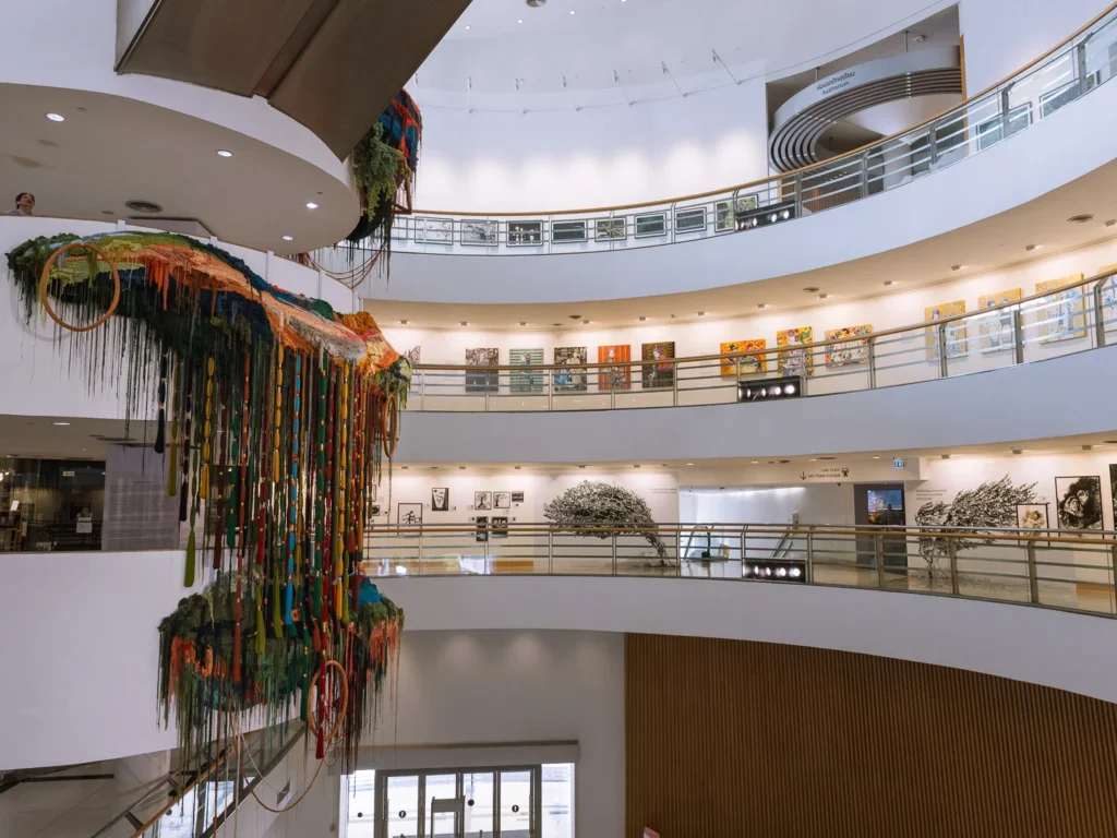 Multi-storey atrium of the Bangkok Arts and Culture Centre with a large textile installation hanging from the ceiling, Bangkok.
