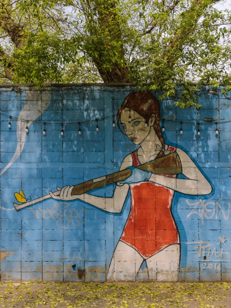 Street art mural of a girl in a red swimsuit holding a baseball bat, Talat Noi neighbourhood, Bangkok
