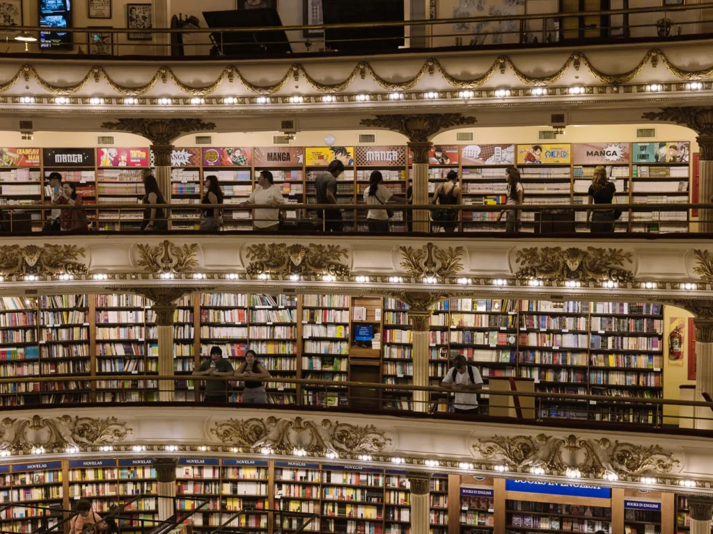 Visitors browsing books on the ornate gilded balconies of El Ateneo Grand Splendid in Buenos Aires, with shelves of manga, novels and English-language books lining the theatre boxes