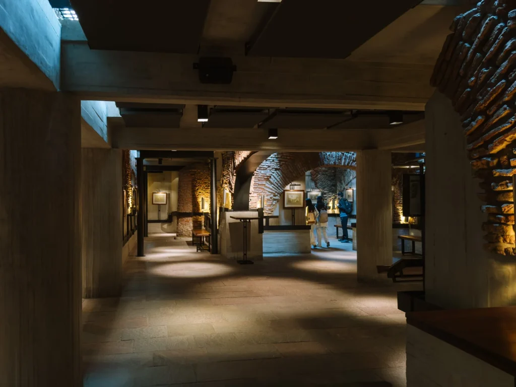 A long excavated brick tunnel at El Zanjón de Granados in San Telmo, Buenos Aires, with vaulted ceilings, stone columns and uplighting illuminating the ancient passageways