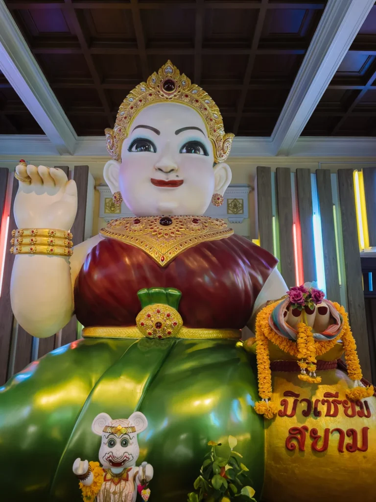 A large, colourful figurine of a Thai goddess in traditional dress and gold jewellery at the Museum of Siam, Bangkok.