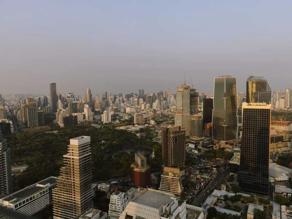 The Bangkok skyline at dusk, looking out over Lumpini Park and the towers of the Silom and Sathorn districts.