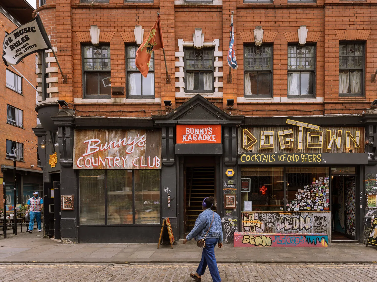 Front of Bunny’s Country Club and Dogtown in Manchester’s Northern Quarter, with colourful signage and a cobbled street in the foreground.