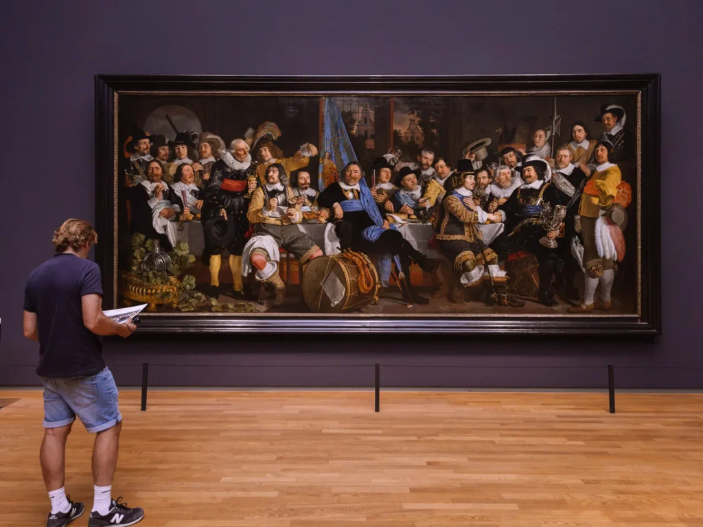 Visitor viewing Banquet at the Crossbowmen’s Guild in Celebration of the Treaty of Münster at the Rijksmuseum
