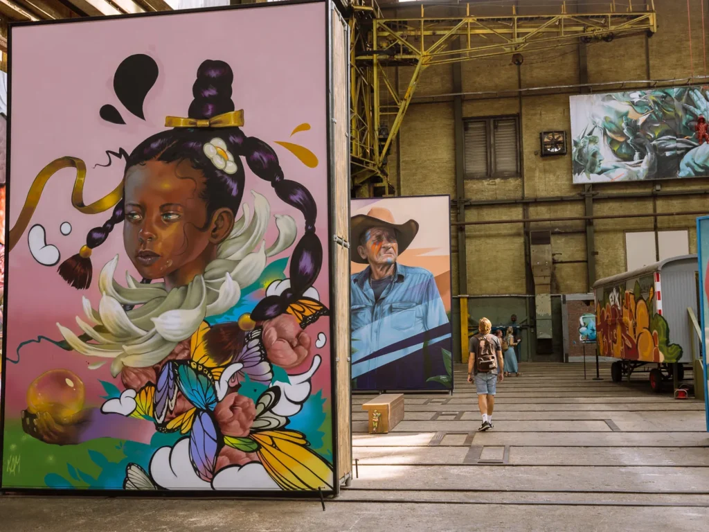 Colourful portrait murals displayed inside the industrial hall at STRAAT Museum in Amsterdam