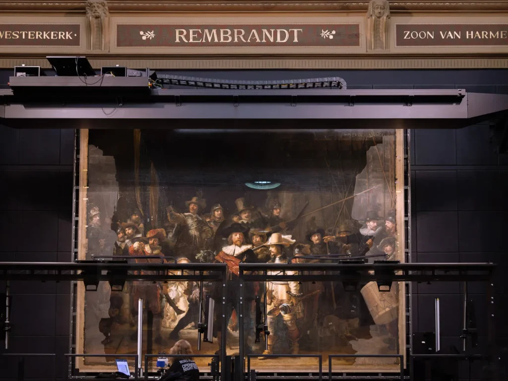 Rembrandt’s The Night Watch behind the glass conservation chamber during Operation Night Watch at the Rijksmuseum