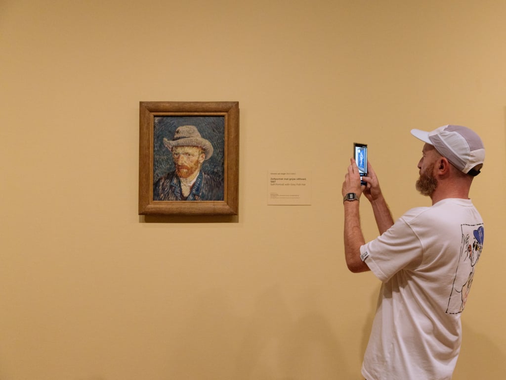 Visitor photographing Vincent van Gogh’s Self-Portrait with Grey Felt Hat at the Van Gogh Museum