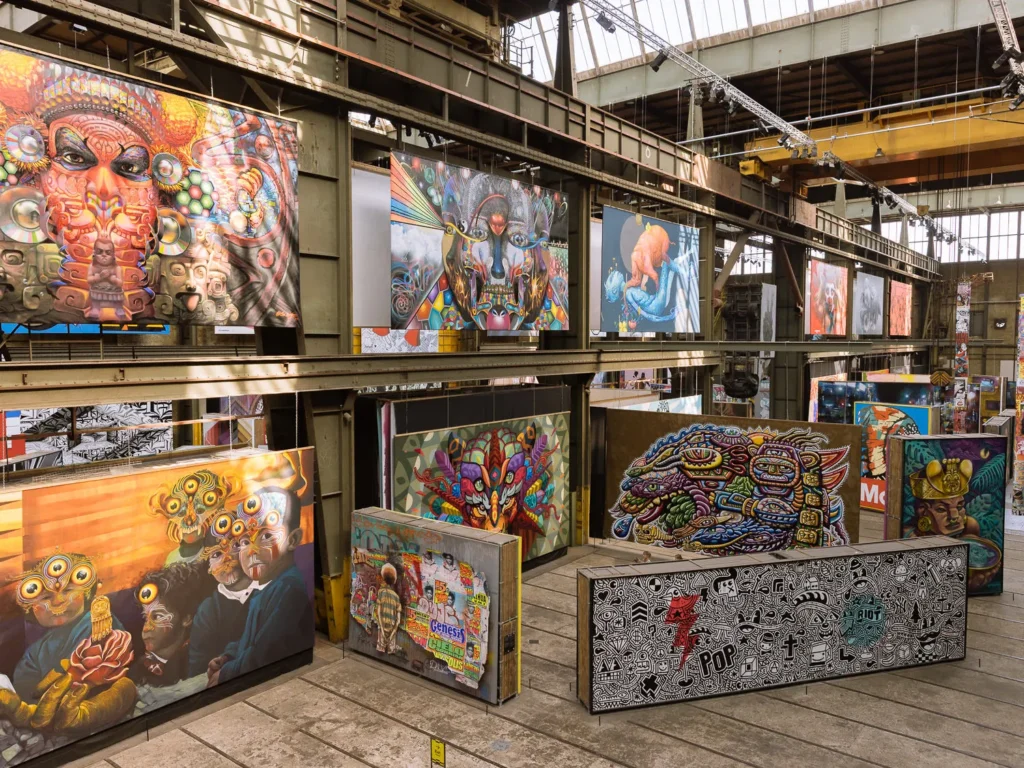 Large-scale street-art murals displayed throughout the former shipyard hall at STRAAT Museum in Amsterdam