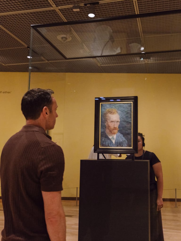 Visitor viewing a Vincent van Gogh self-portrait in the Van Gogh Museum, Amsterdam